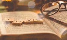 Photo of Bible with Scrabble tiles spelling 'love'