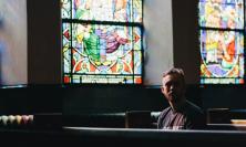 Photo of man sitting on church pew by Kyle Fredrickson on Unsplash